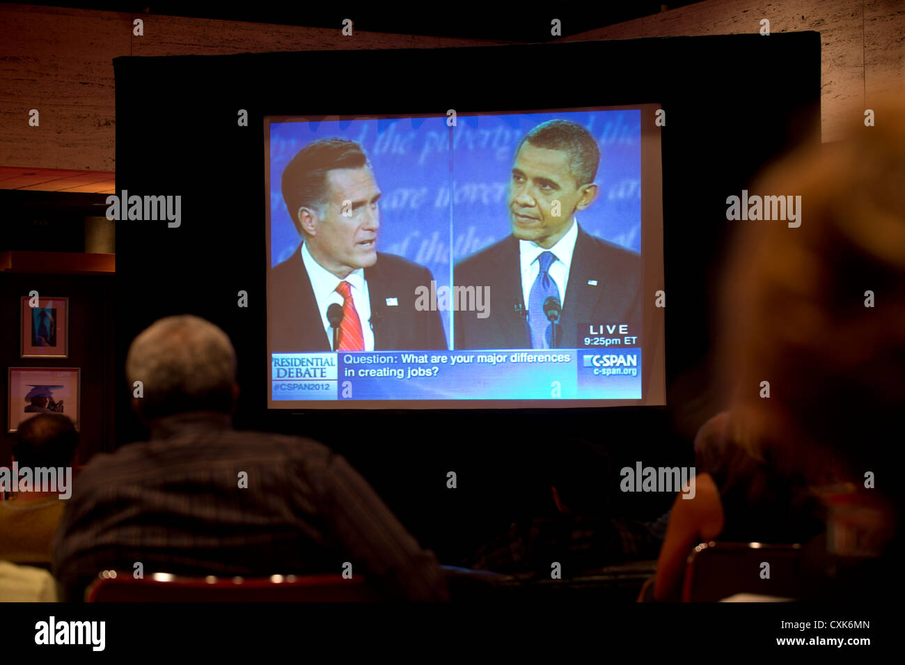 Likely voters watch large TV screen showing televised debate between US presidential candidates Barack Obama and Mitt Romney Stock Photo