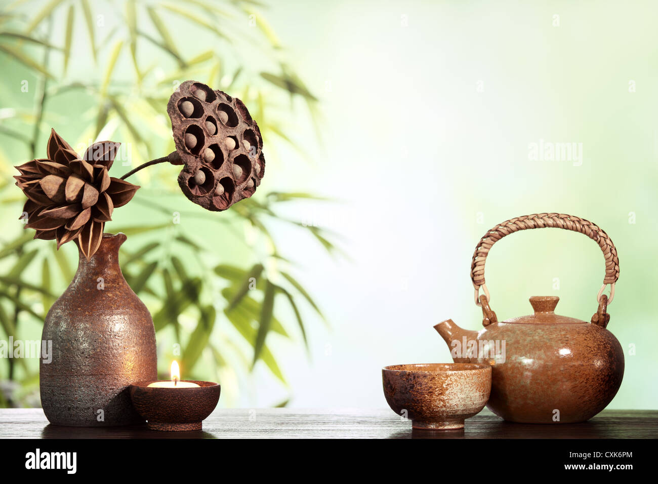 Teapot and cups on table with bamboo leaves. Stock Photo