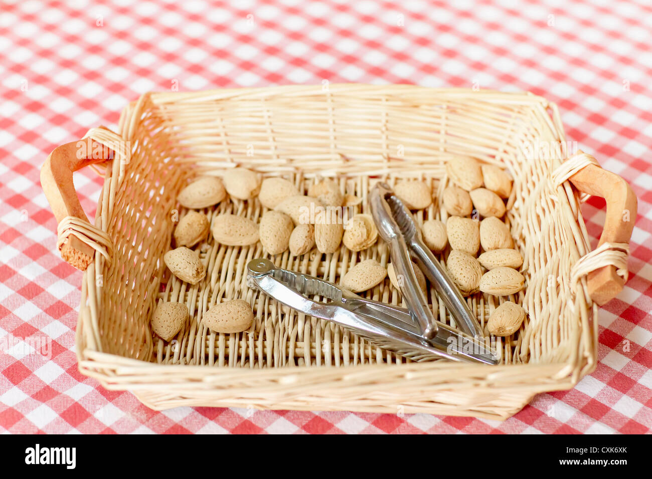 Almonds and nutcrackers in a basket. Stock Photo