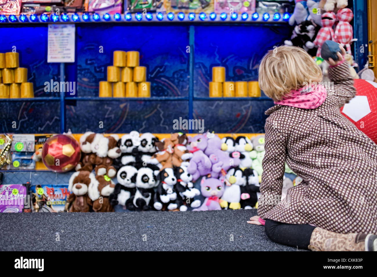 Little girl playing throwing ball game at the fun fair Stock Photo Alamy