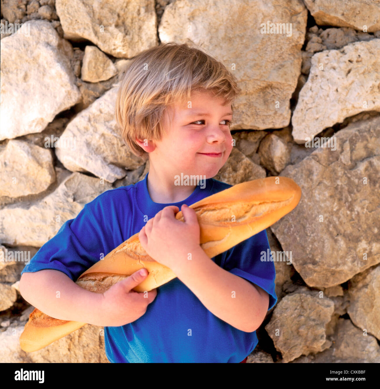YOUNG BOY HOLDING FRENCH BREAD BAGUETTE Stock Photo