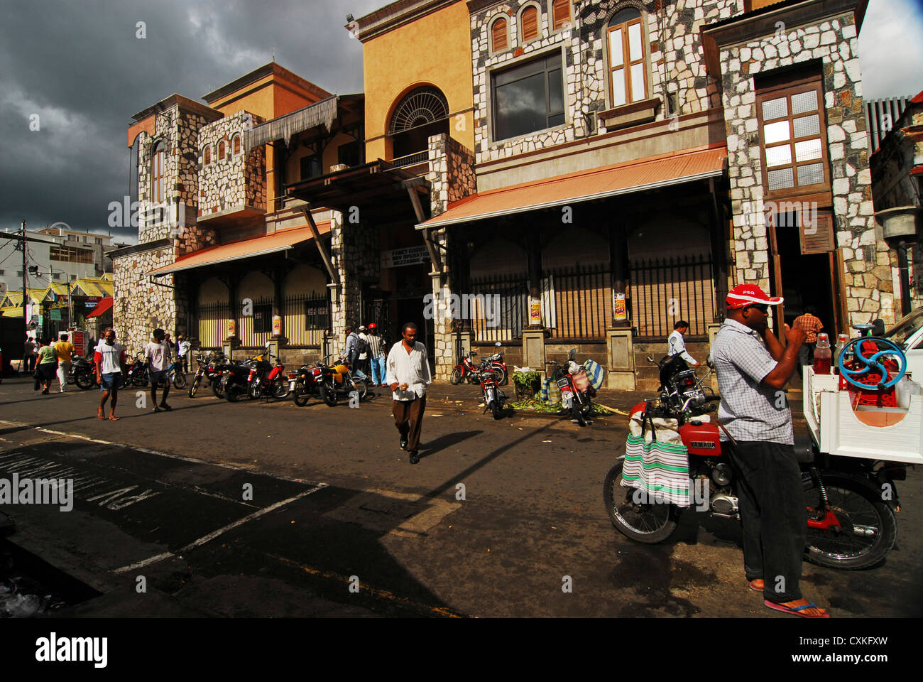 Mauritius, Port Louis, people on road with the view of vehicles parked in front of the building Stock Photo