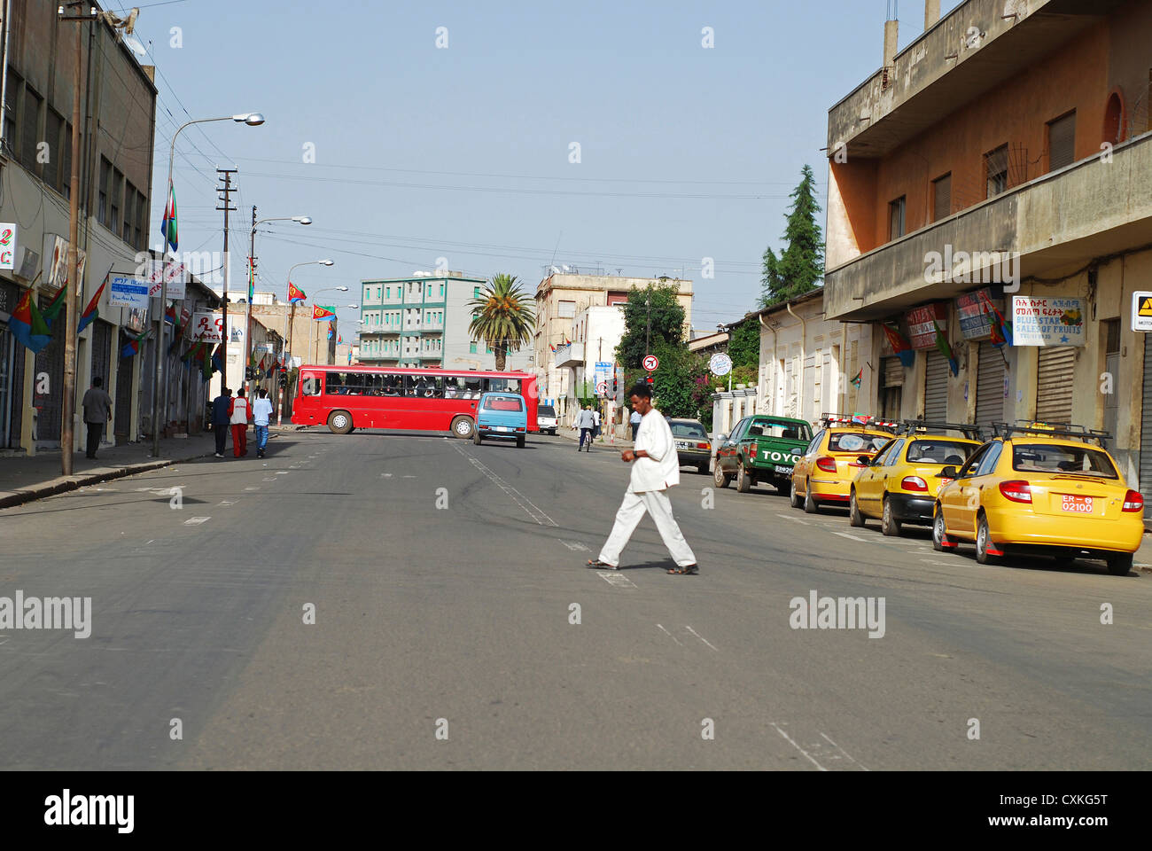 Eritrea, Asmara, man walking on the road by parked vehicles Stock Photo