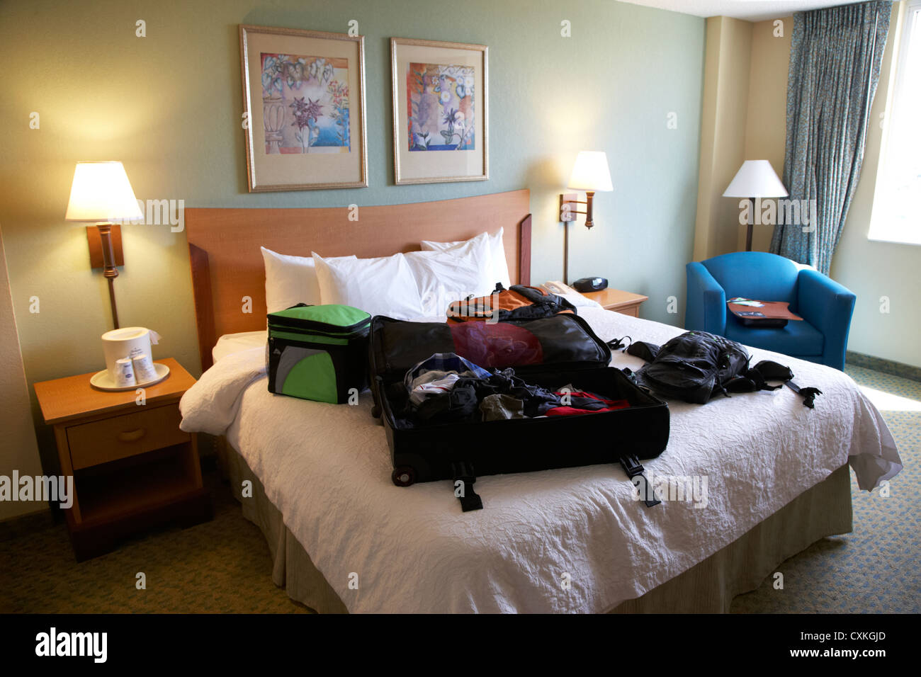 luggage lying on king size bed in a us hotel room miami florida usa