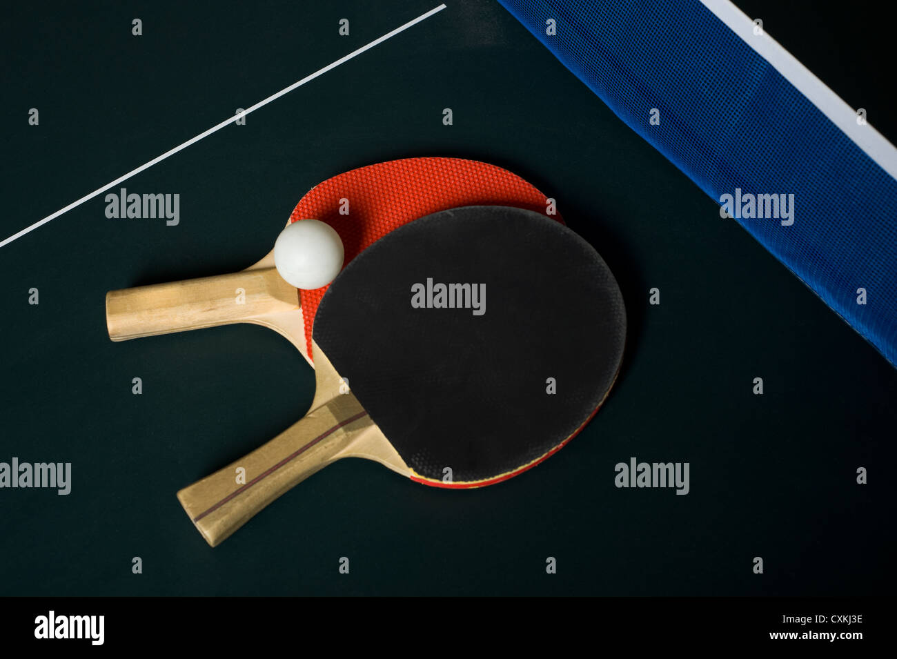 Ping pong or table tennis paddles on a table with net and a ball, with copy space Stock Photo