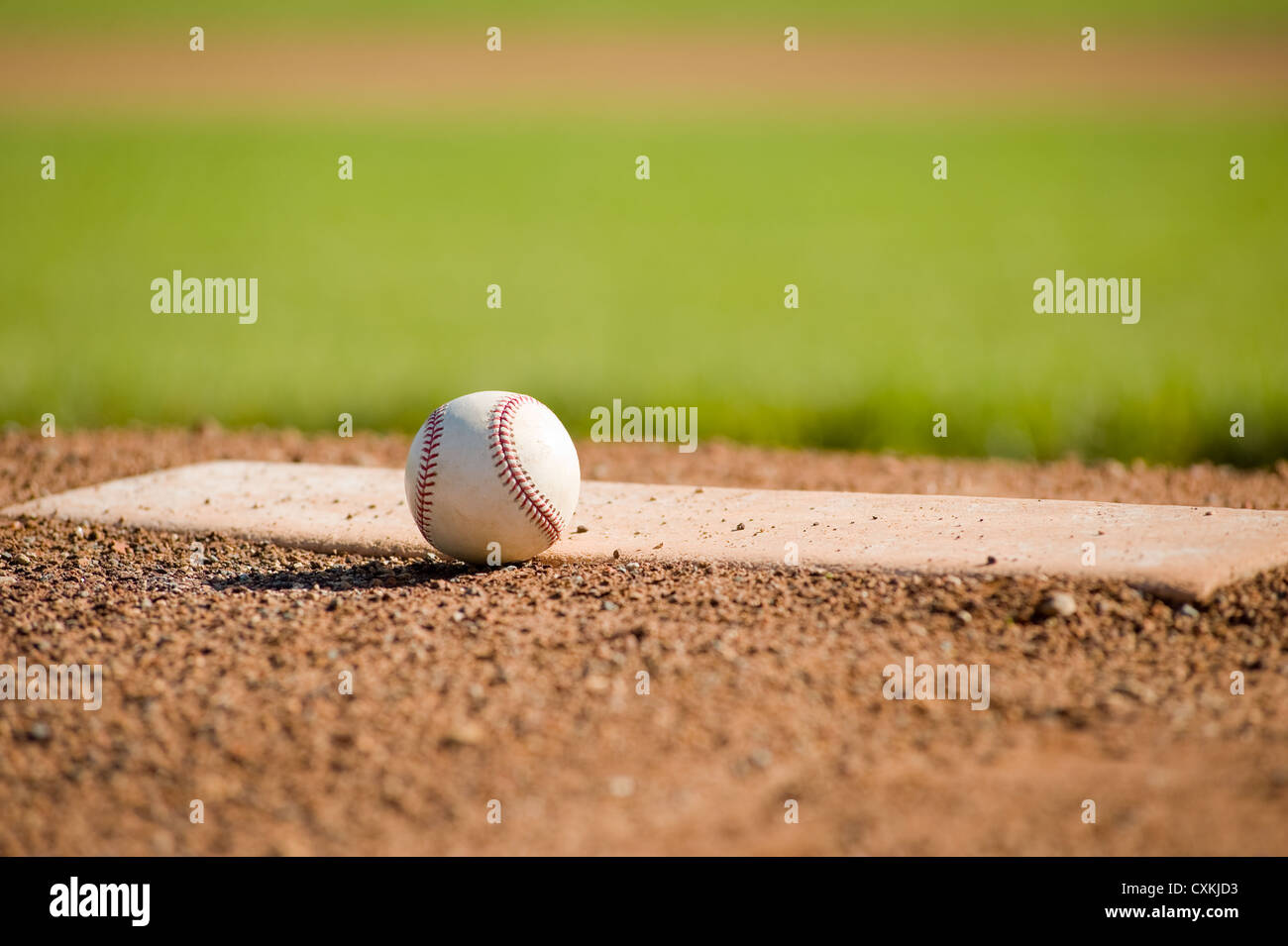 A white leather baseball lying on top of the pitcher's mound at a baseball field with copy space Stock Photo