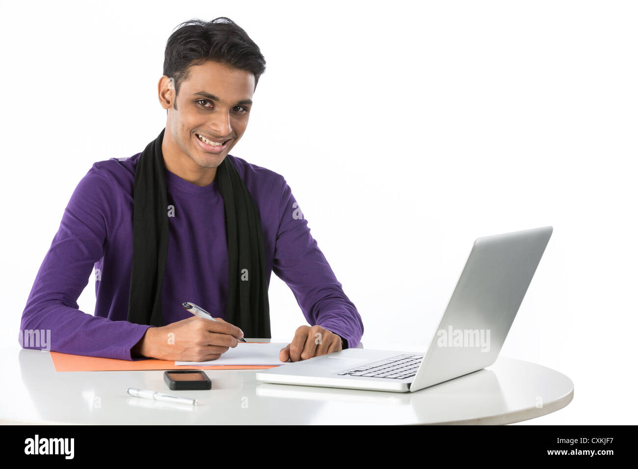 Asian Male Student Working At A Desk With A Laptop Stock Photo