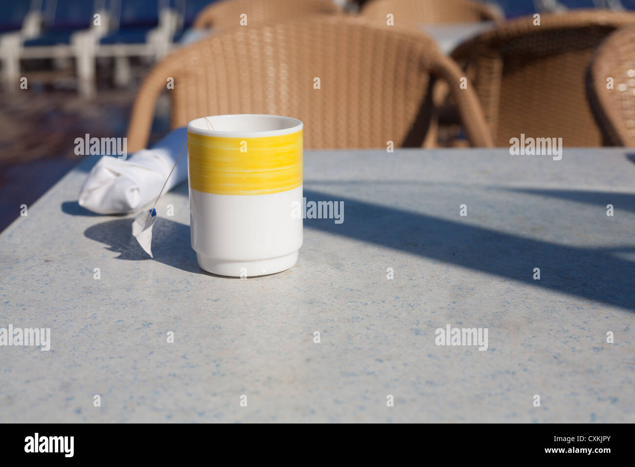 A coffee cup with a yellow strip on a table on a cruise ship.tea Stock Photo
