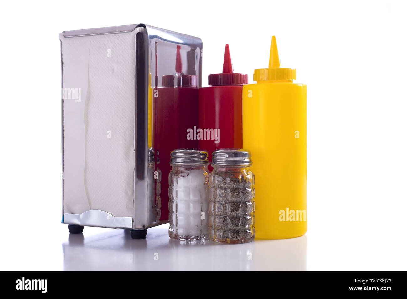 Napkin holder, mustard and ketchup and a salt and pepper shaker on a white background Stock