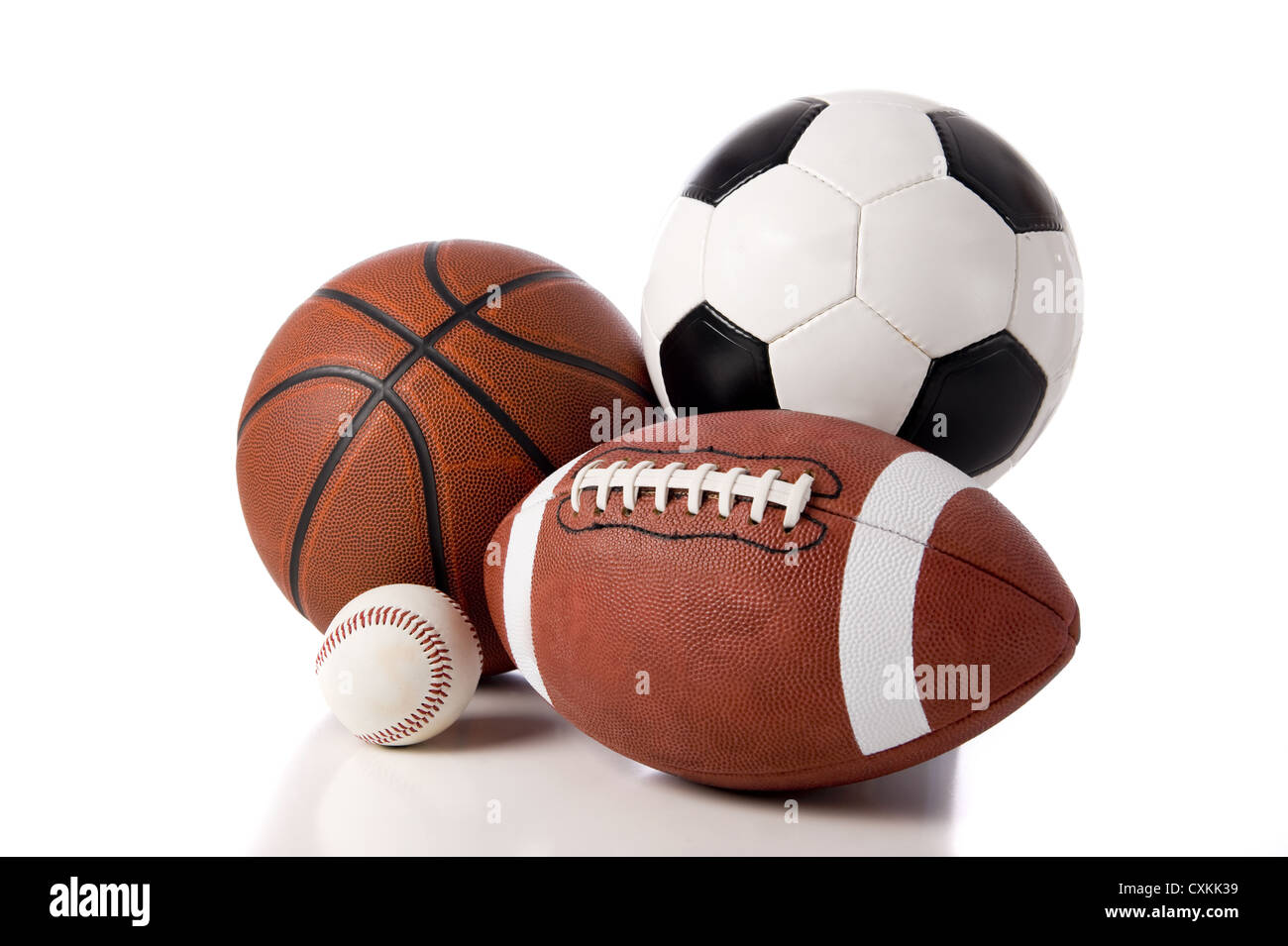 A group of sports balls on a white background, including a baseball, an American football, a basketball, and a soccer ball Stock Photo