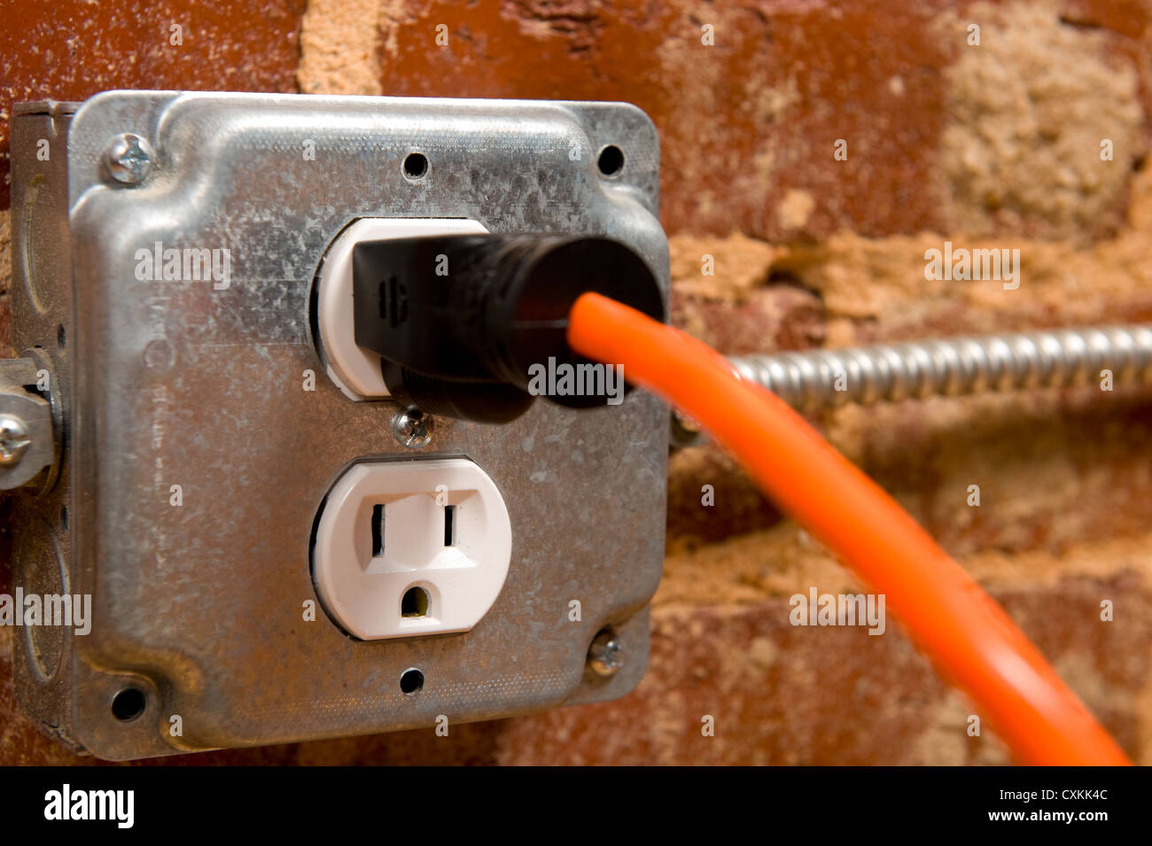 Electrical plug on a brick wall with a cord or extension cord plugged in,  concept of connecting or power Stock Photo - Alamy
