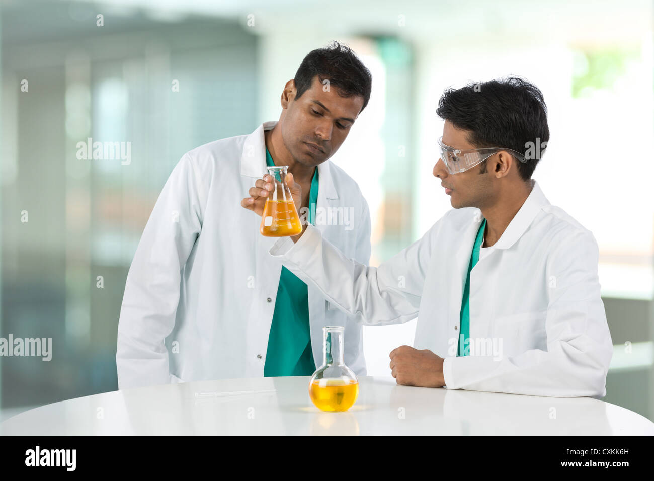 Two Indian scientists analyzing solution. Stock Photo