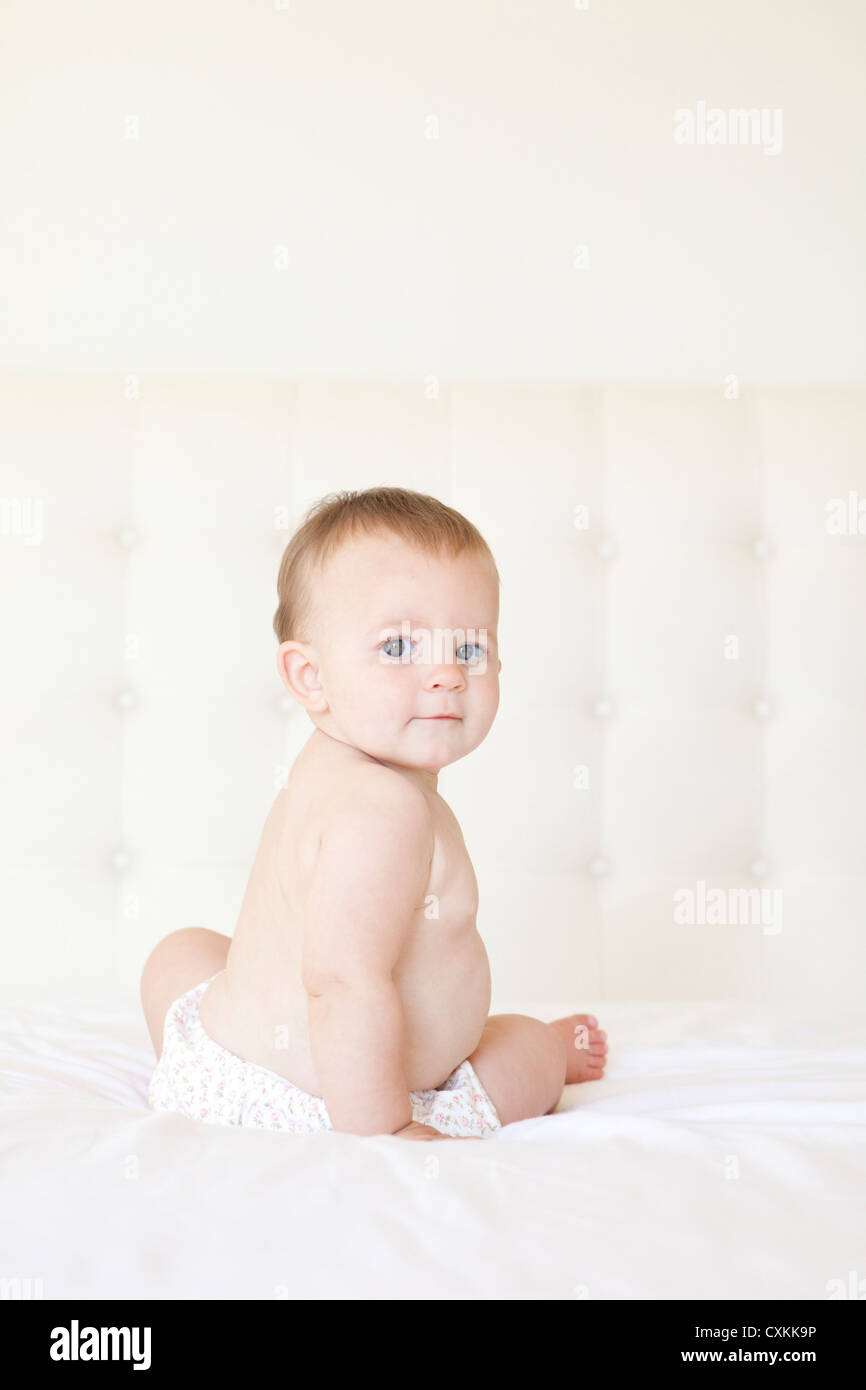 Baby sitting on bed hi-res stock photography and images - Alamy