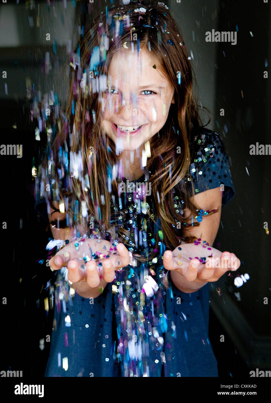 Glitter sprinkling down on young girl Stock Photo