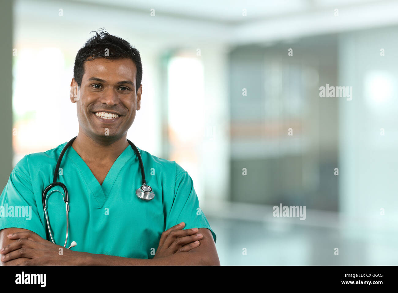 Male Indian Doctor wearing Green Scrubs in modern hospital Stock Photo