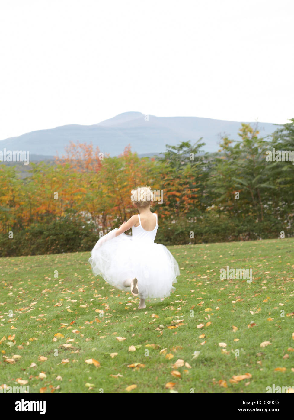 girl running in ballet costume in field Stock Photo