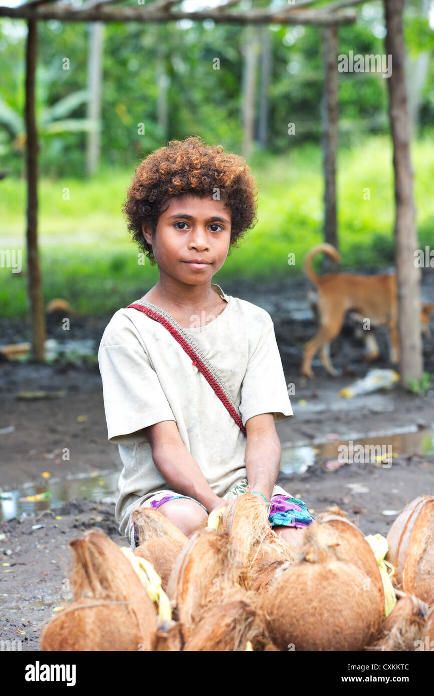 Young girl selling coconuts at a roadside market, Papua New Guinea Stock Photo