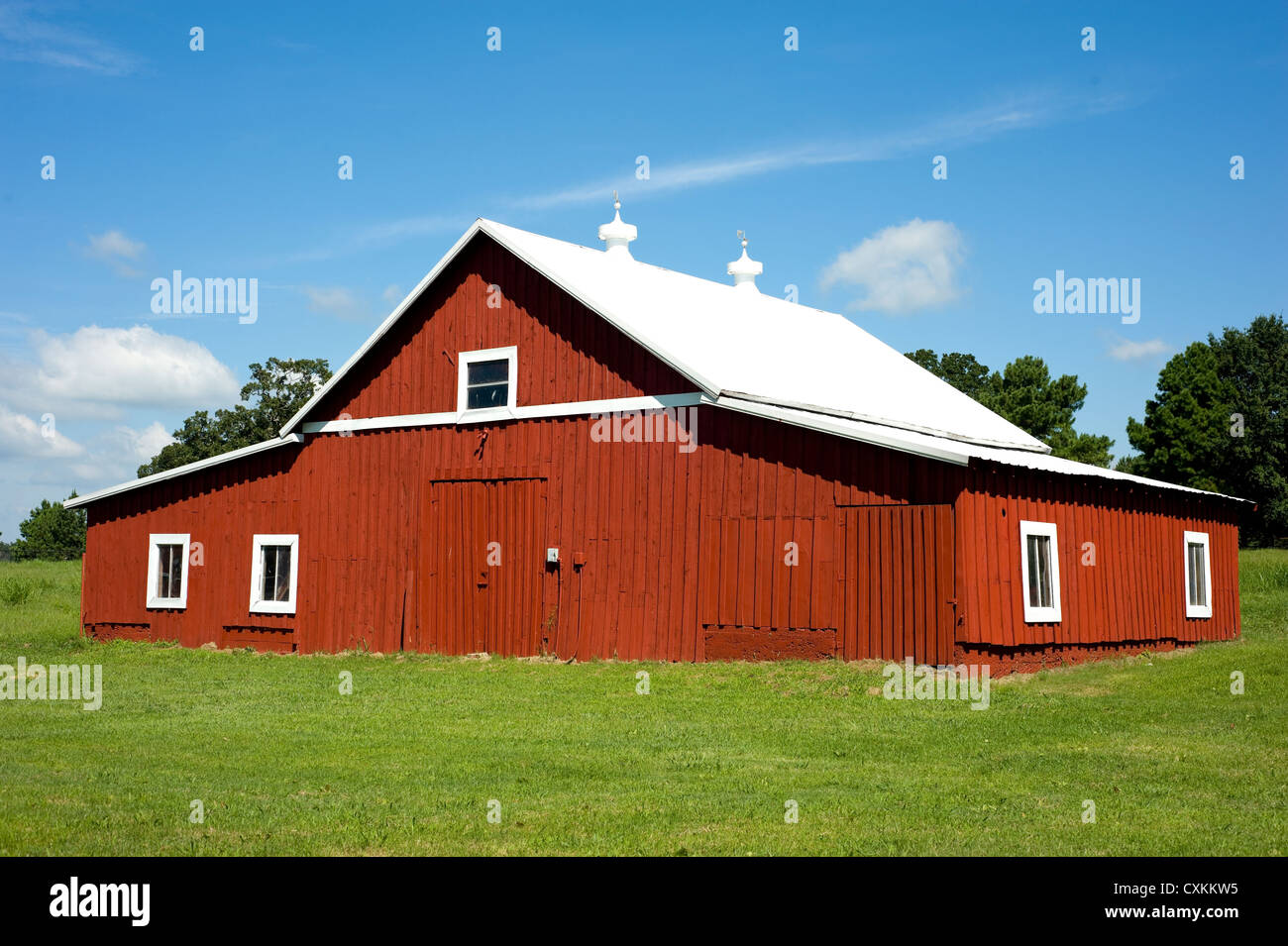 A Freshly Painted Red Barn On A Green Meadow On A Beautiful Sunny