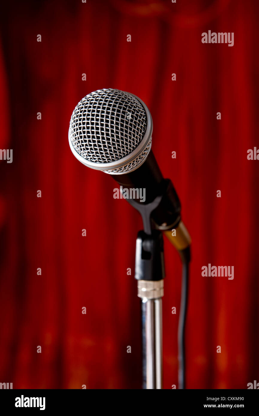 A microphone on a red curtain stage background Stock Photo - Alamy