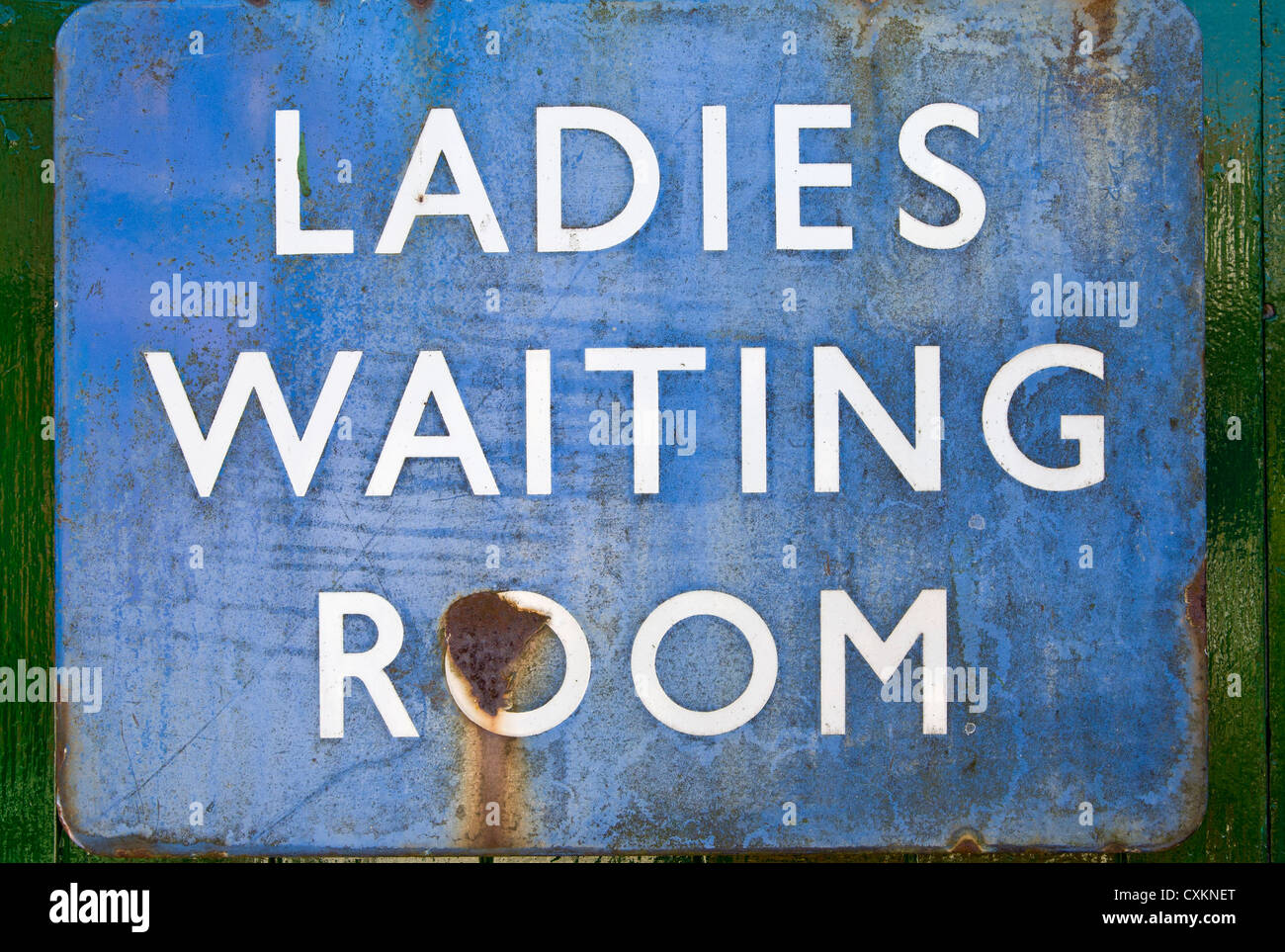 Metal Ladies Waiting Room station sign. Blue and rusting. Stock Photo