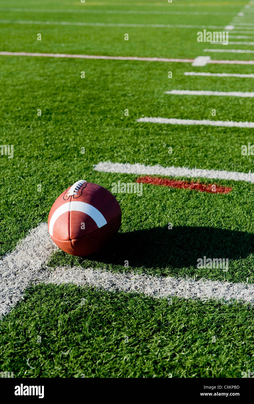 A brown leather American football on a green football field Stock Photo