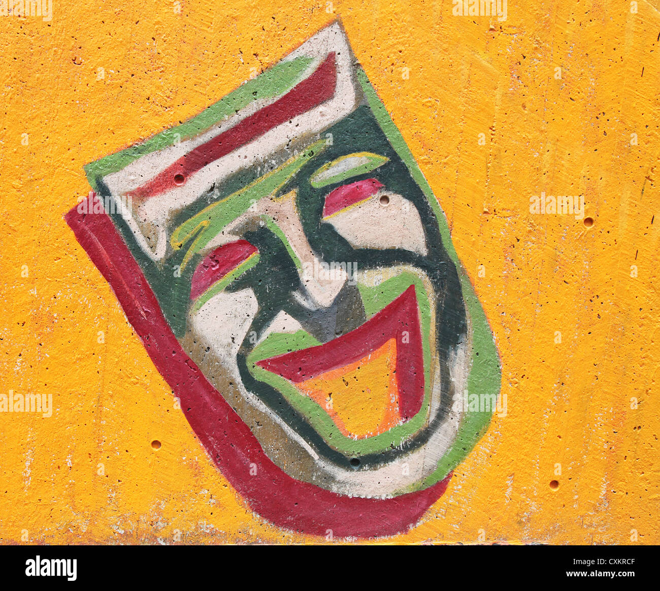 Graffiti of a theatrical mask representing comedy painted on a cement wall. Stock Photo