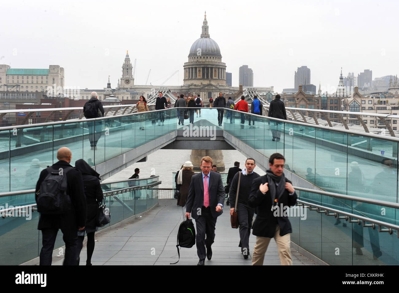Commuters make their way to work on Millennium Bridge, London, UK Stock Photo