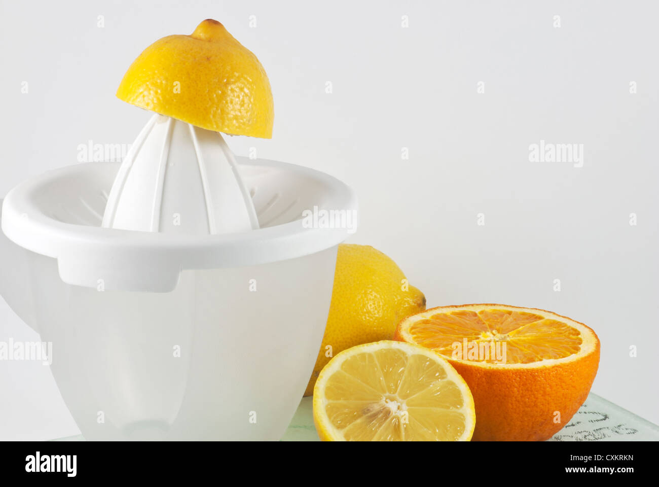 Lemons and oranges with citrus juicer Stock Photo Alamy