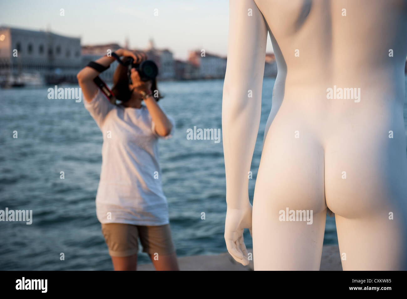 A tourist taking pictures to the Charles Ray's statue 'boy with a frog', Venice, Italy. Stock Photo