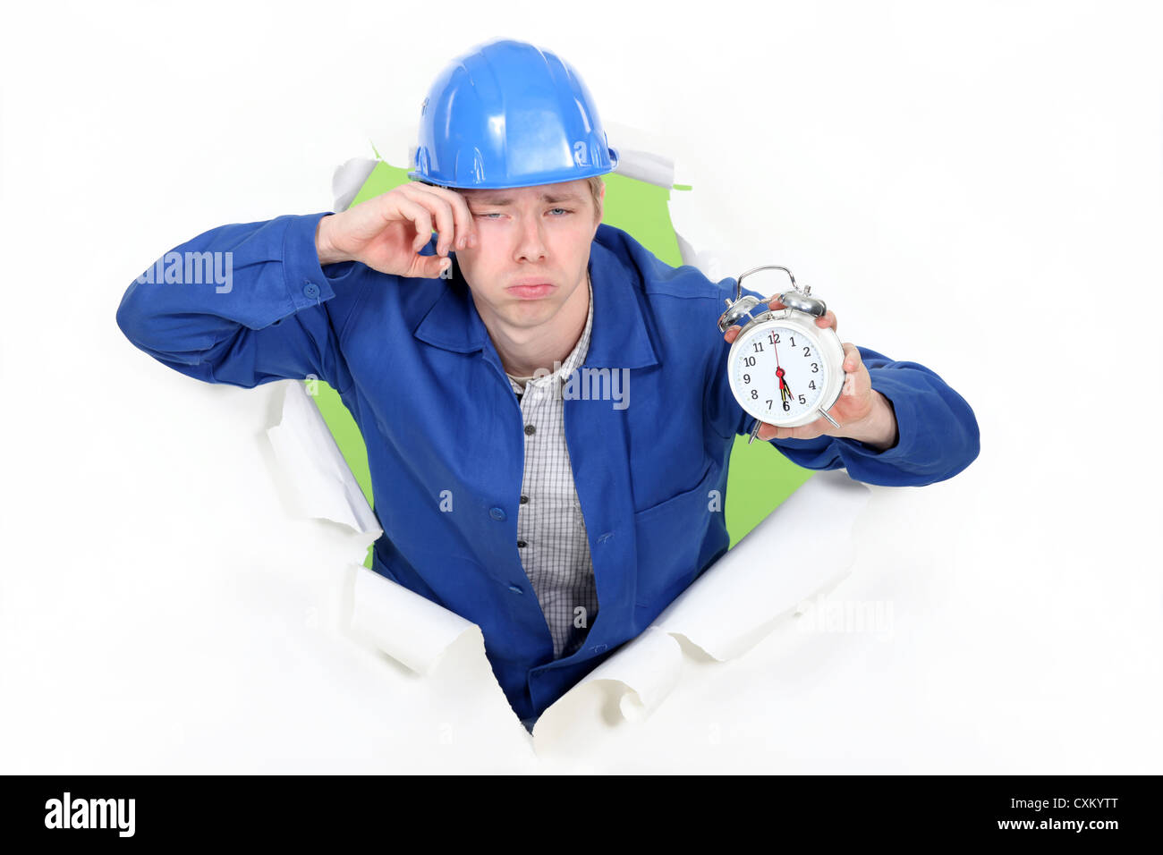 Bleary eyed construction worker with an alarm clock Stock Photo