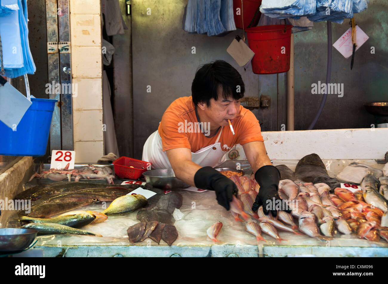 Fishmonger smoking on the job at a Hong Kong wet market Stock Photo