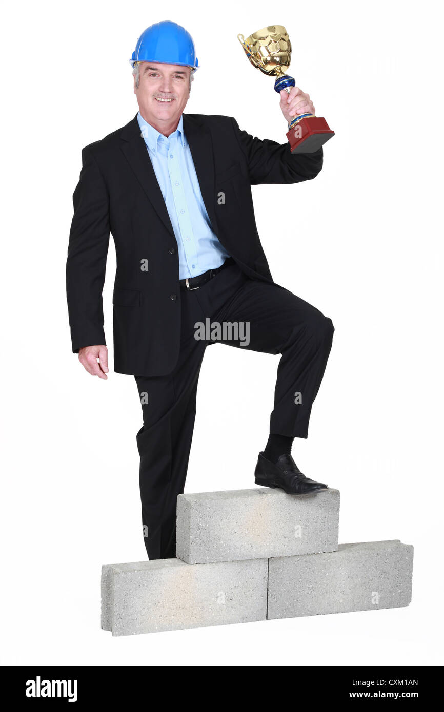 Businessman holding trophy Stock Photo