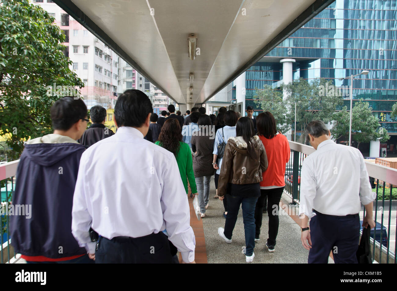 Commuters walking along a busy elevated walkway in Wan Chai, Hong Kong Stock Photo