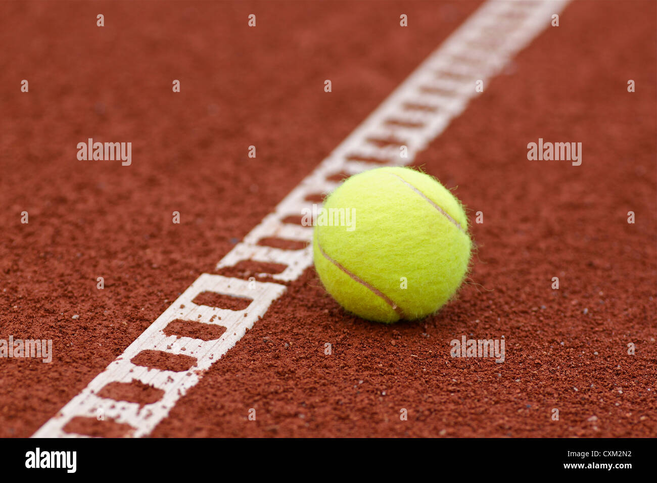 Closeup tennis ball laying on a clay tennis court Stock Photo Alamy