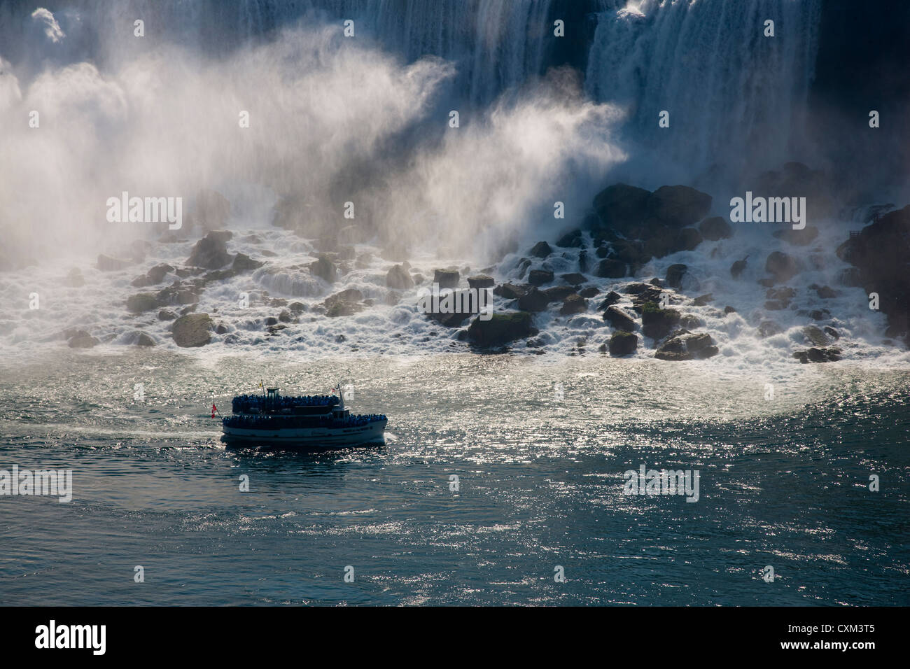 The Maid of the Mist tour boat passing The American Falls in Niagara Stock Photo