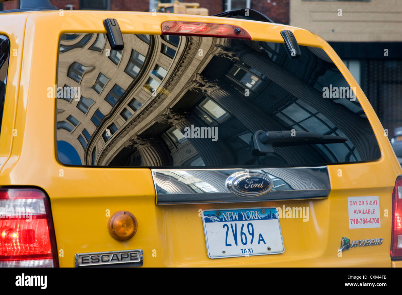 Building refelected in the back windscreen of a New York yellow cab Stock Photo