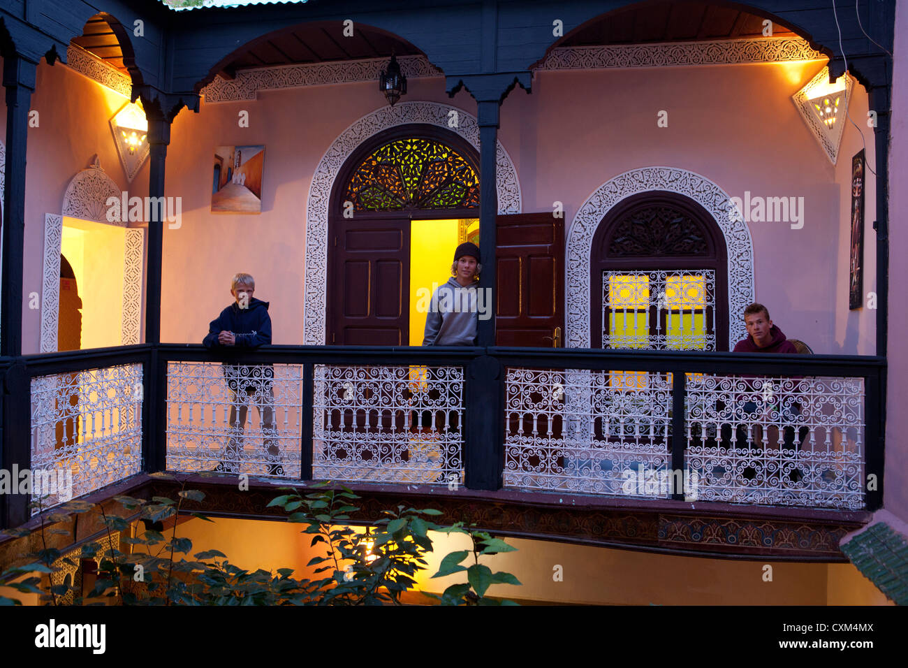 Three boys on balcony in riad, Marrakech, Morocco Stock Photo