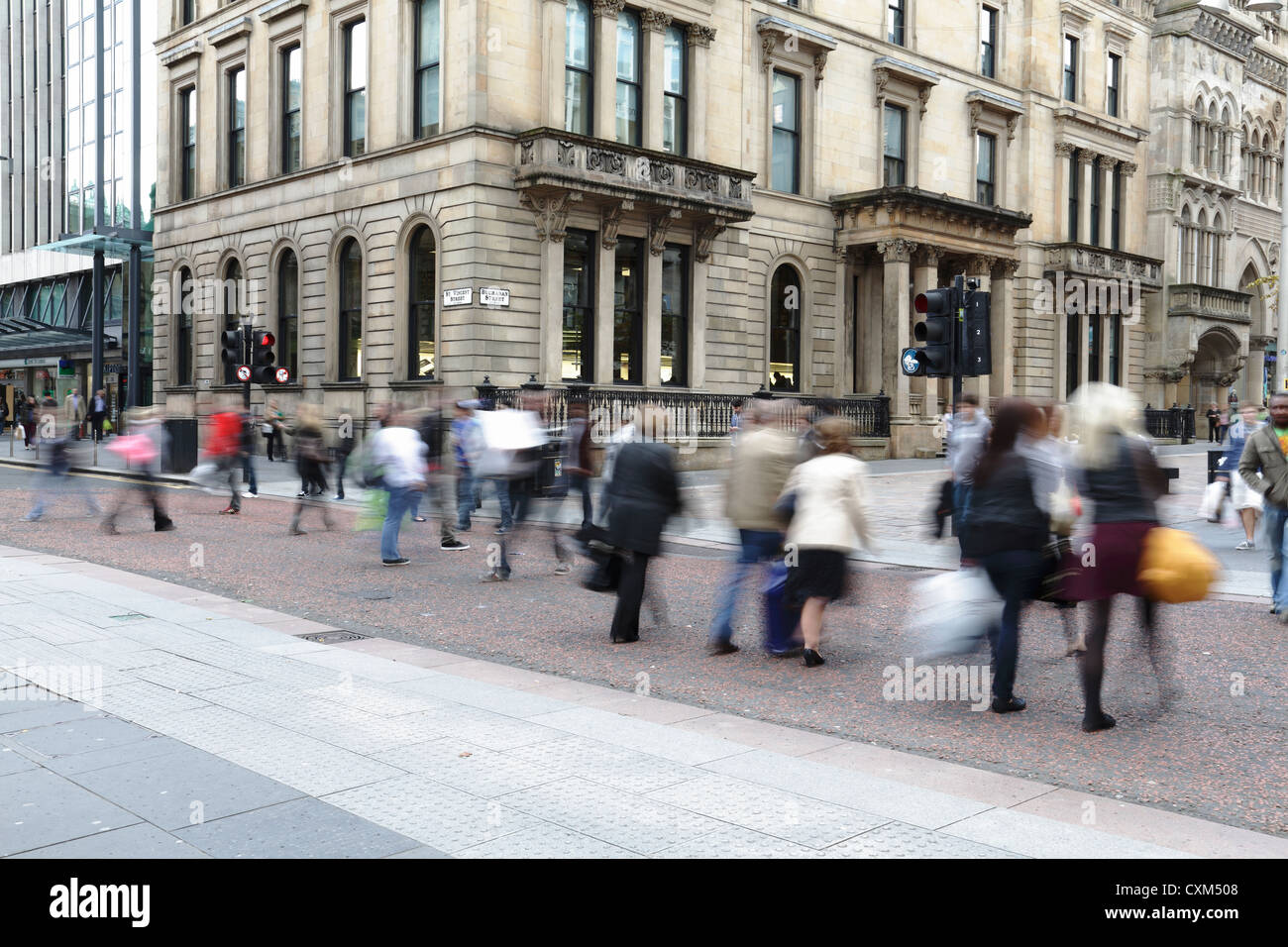 Motion blurred pedestrians crossing St Vincent Street at Buchanan Street in Glasgow city centre, Scotland, UK Stock Photo