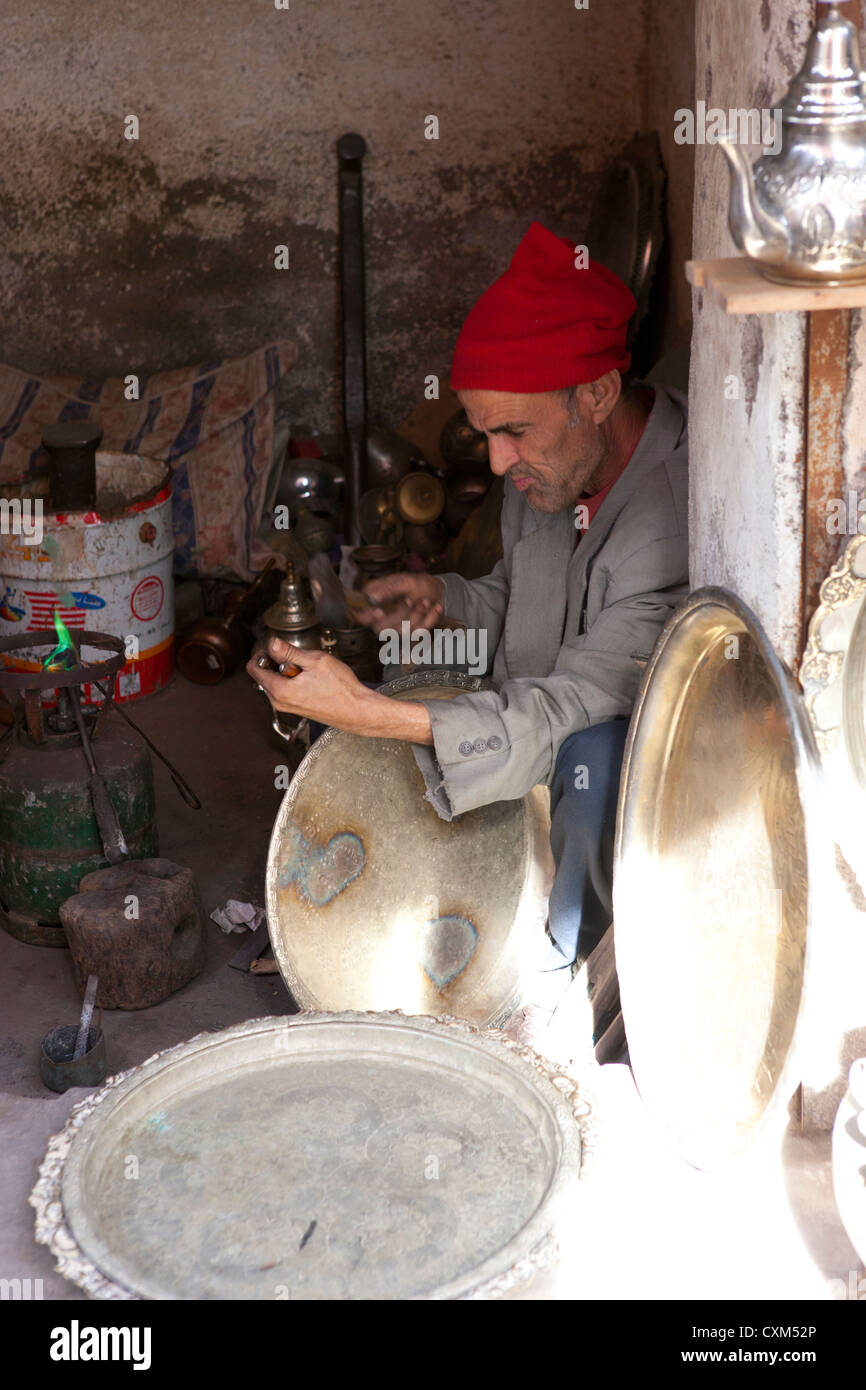 Moroccan man making pattern on brass plate, Marrakech, Morocco Stock Photo