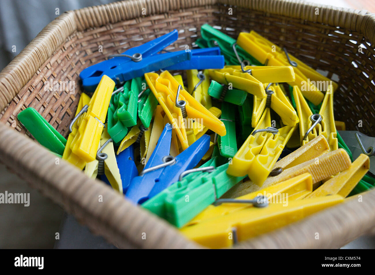 Pile of yellow, blue and green plastic clothes pegs Stock Photo