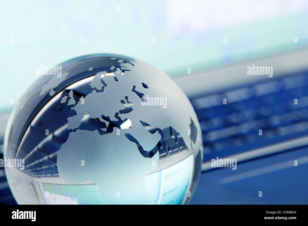 Crystal globe focusing on the Europe and Africa area on a laptop keyboard,  toned image. Stock Photo