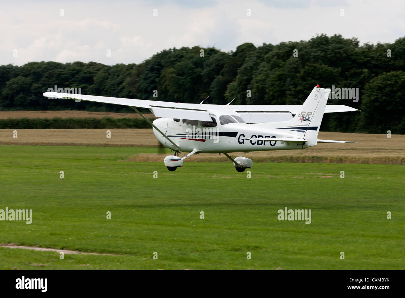 Cessna 172S Skyhawk G-CBFO landing on grass runway Stock Photo