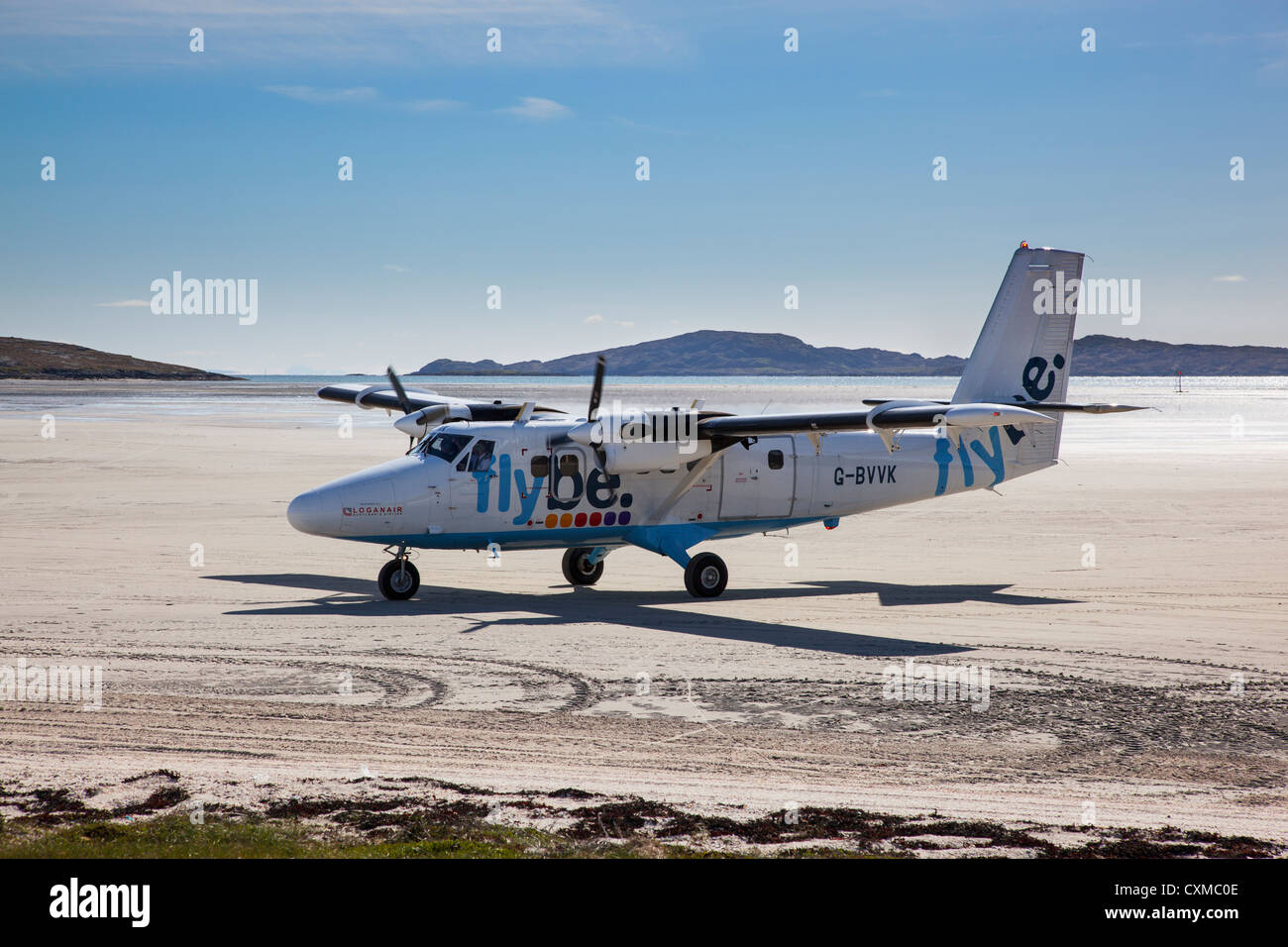 Aircraft taxiing across the beach to the arrivals area (disembarking area) after landing, Barra, Outer Hebrides, Scotland, UK Stock Photo