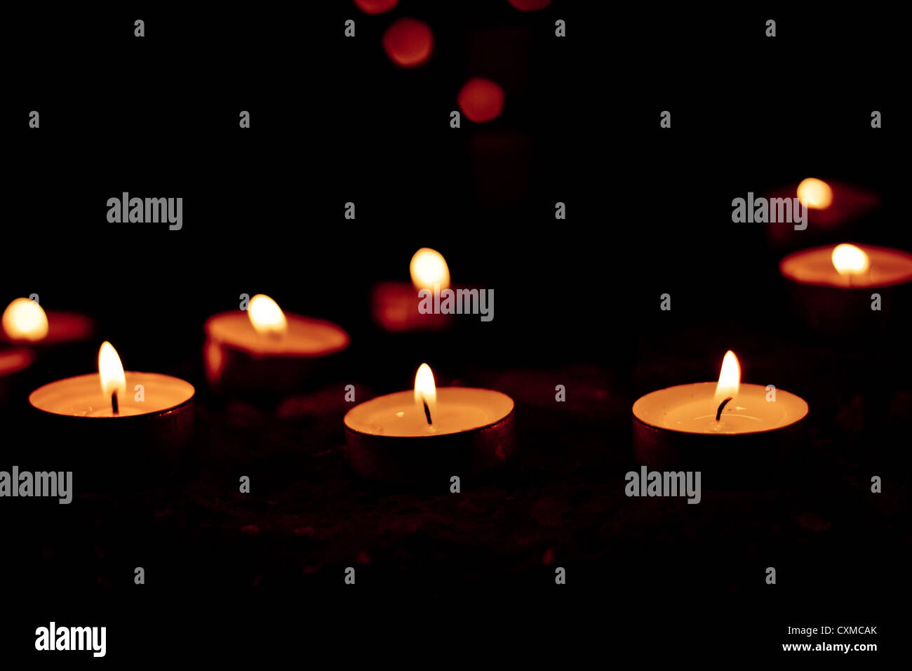 Tea light candles burning in the dark Stock Photo Alamy