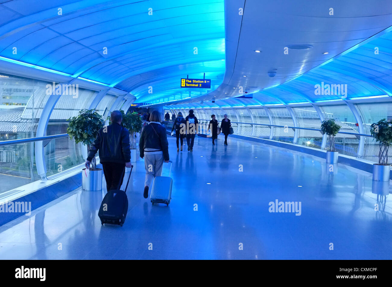 People heading into Manchester Airport on the moving walkway Stock Photo