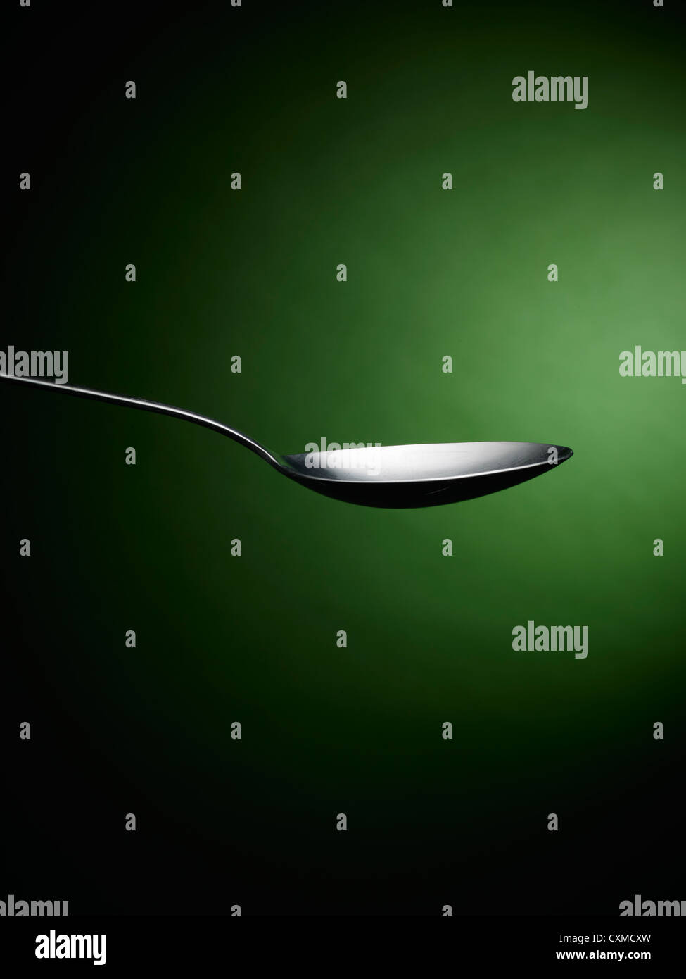 Spoon on a green background Stock Photo