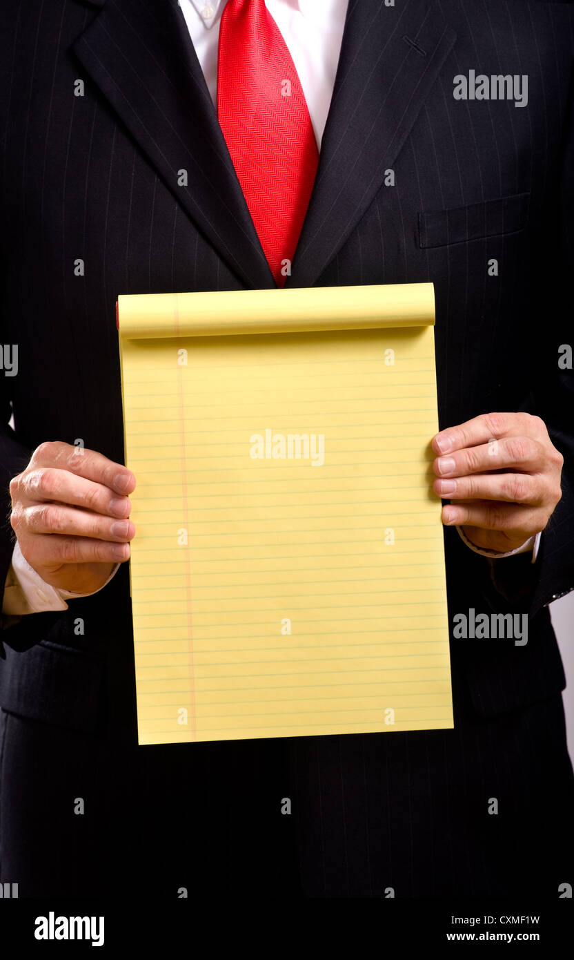 A business man in a blue suit and a red necktie holding a yellow tablet add your own copy or text, business communications Stock Photo