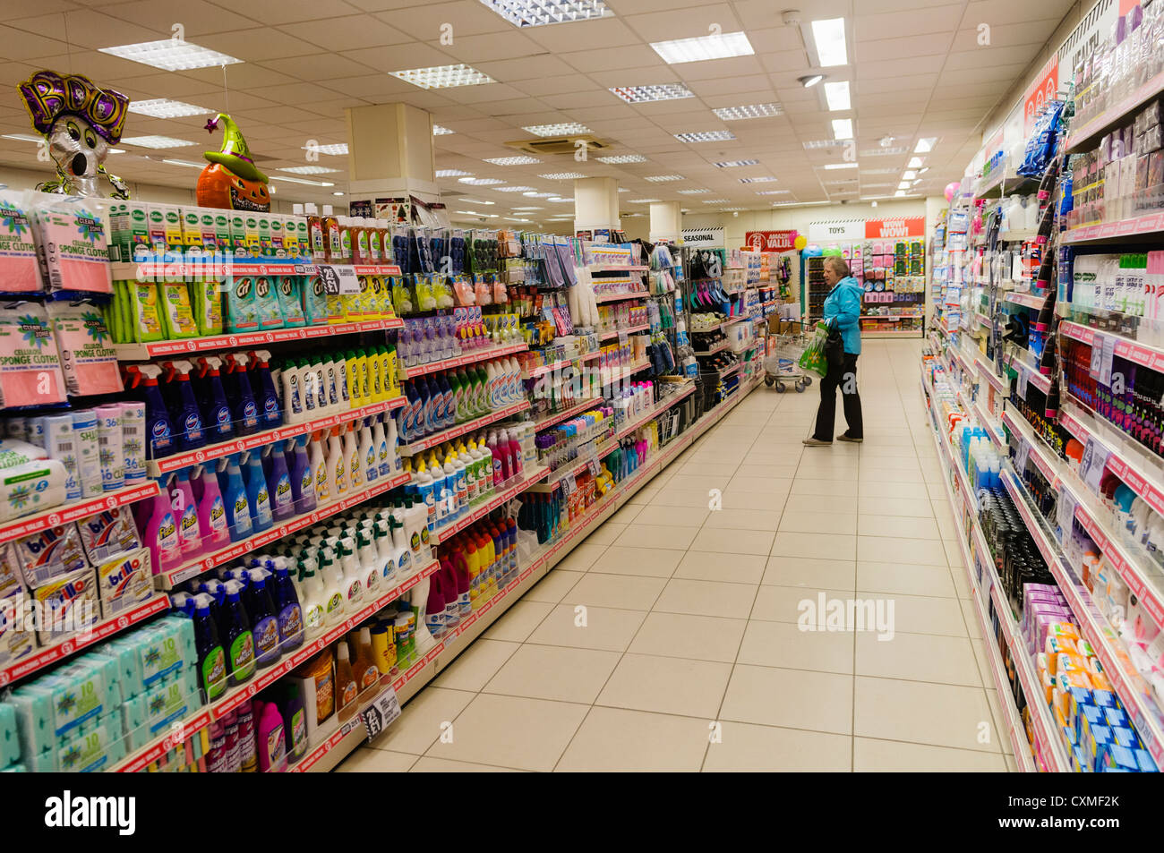 Customer looks at products on shelves in a Poundland shop store. Stock Photo