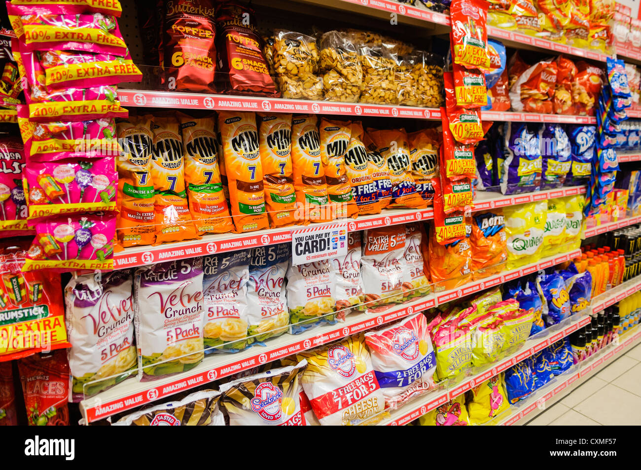packets of branded snack and crisps on sale on the shelves in a poundland CXMF57