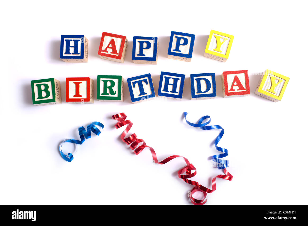 The words 'happy birthday' spelled out in wooded block on a white background with ribbons and copy space Stock Photo